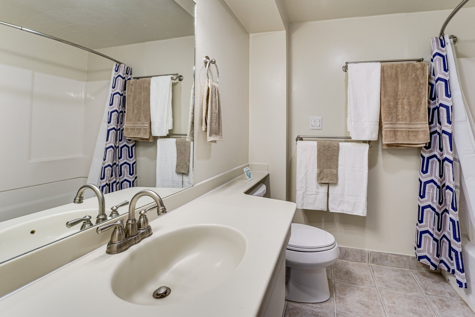 The bathroom includes a tub/shower, sink, storage, toiletries.