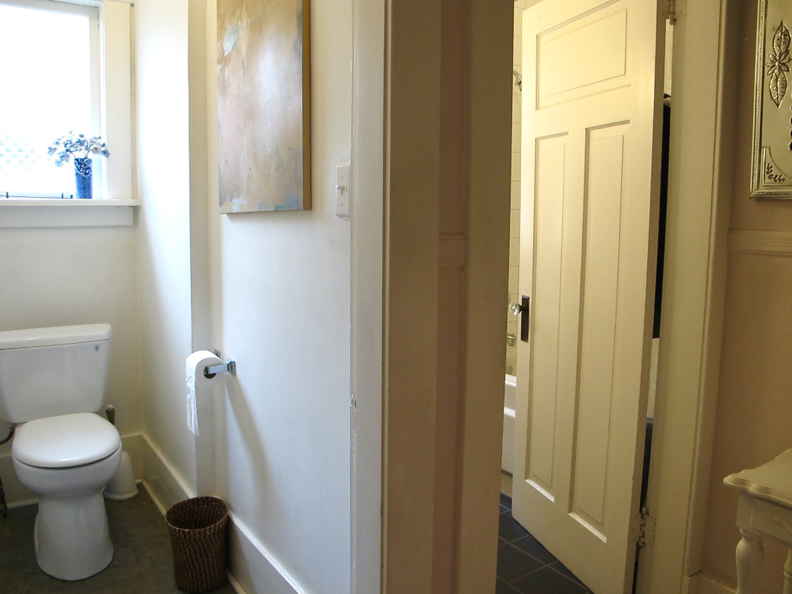 Badezimmer. Die Toilette ist vom Waschbecken, der Badewanne und der Dusche getrennt.