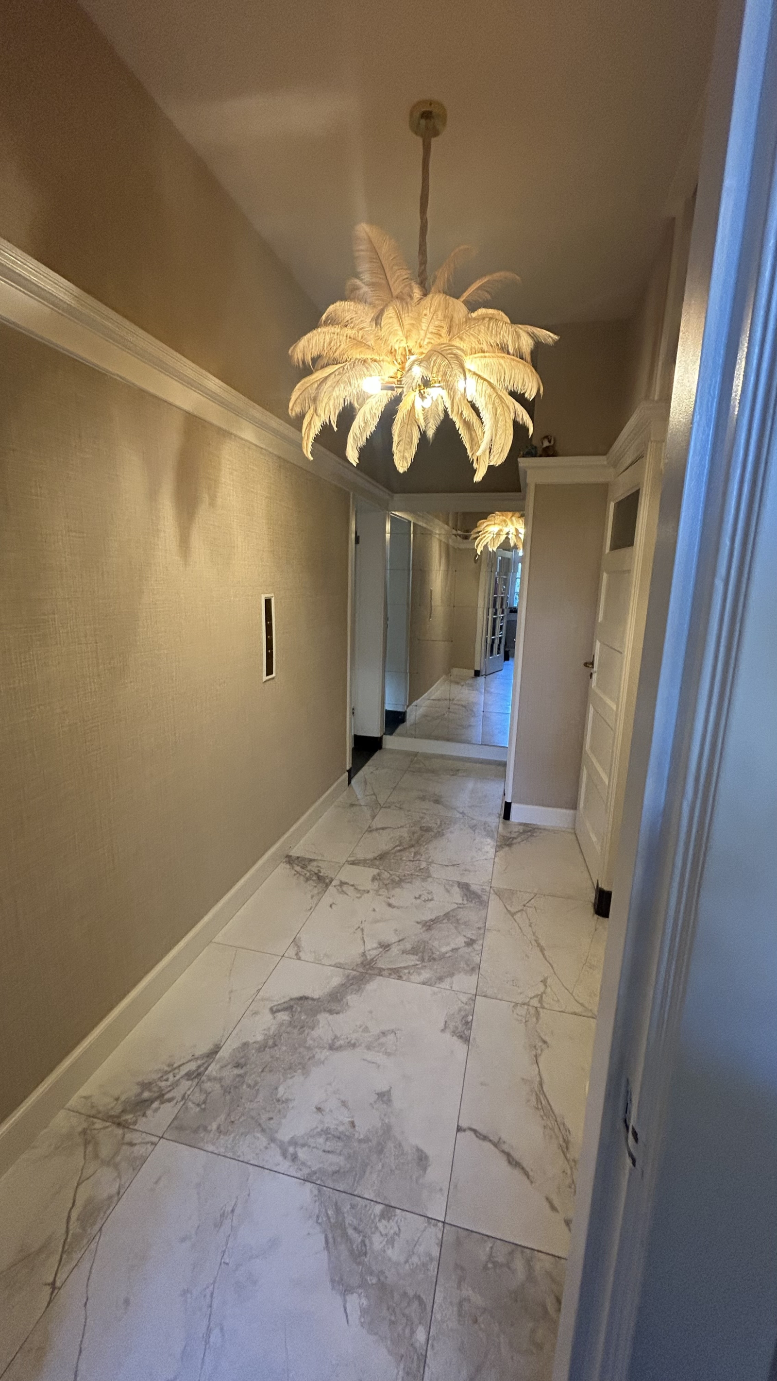 Brede gang met deur naar kelder ( american vries/koelkast) en deur naar wc