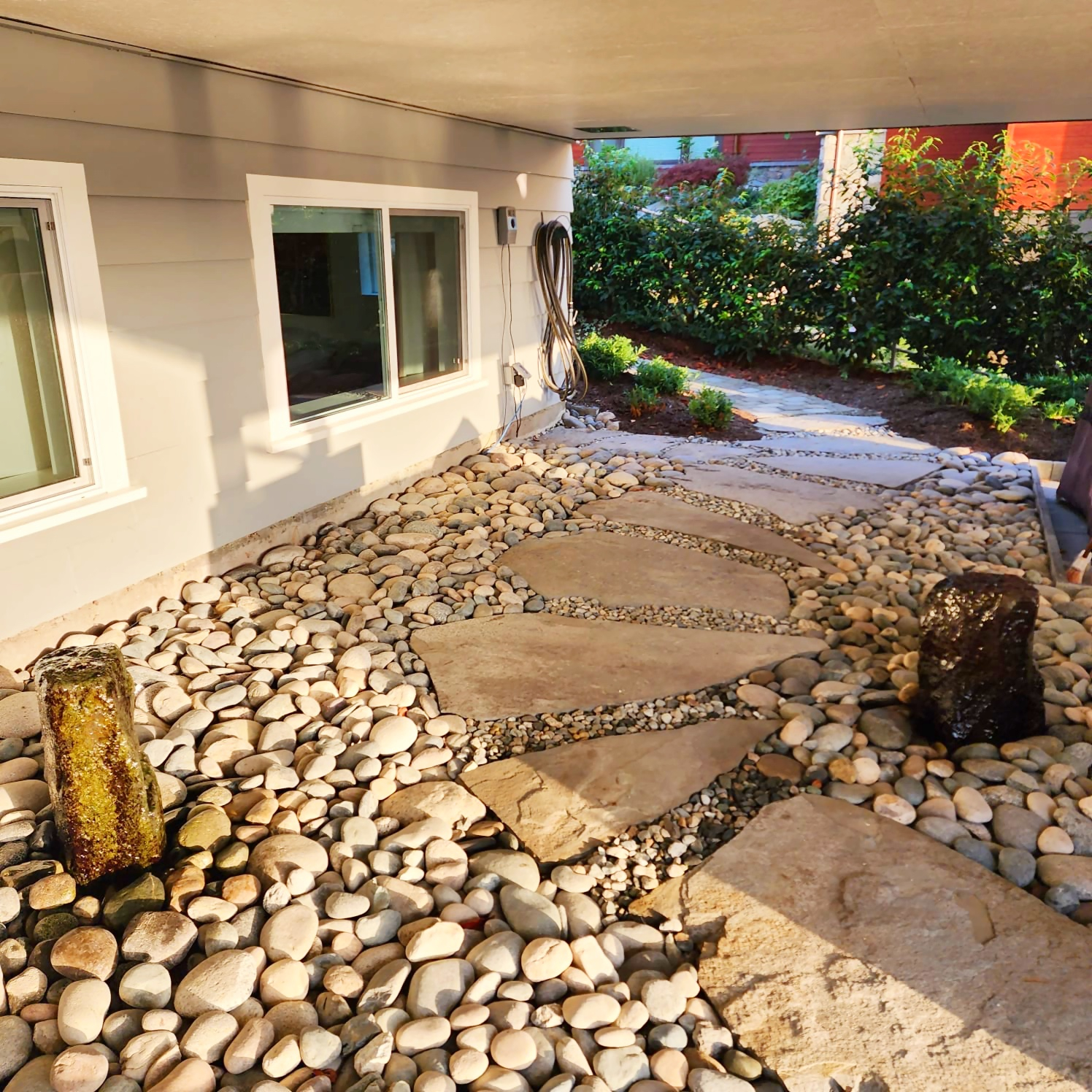 Le chemin à travers le jardin de rocaille mène à un coin salon couvert.