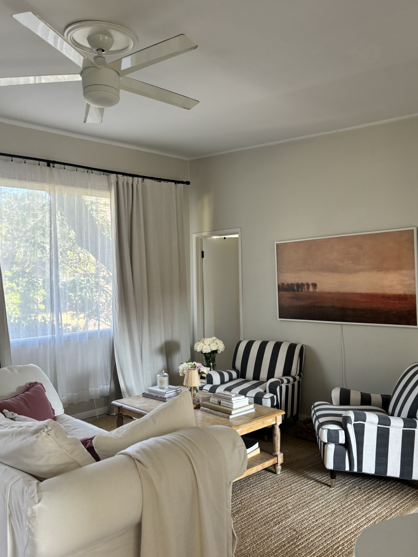 Salón con gran ventana panorámica y sofá cómodo + TV de marco para ver tus programas favoritos