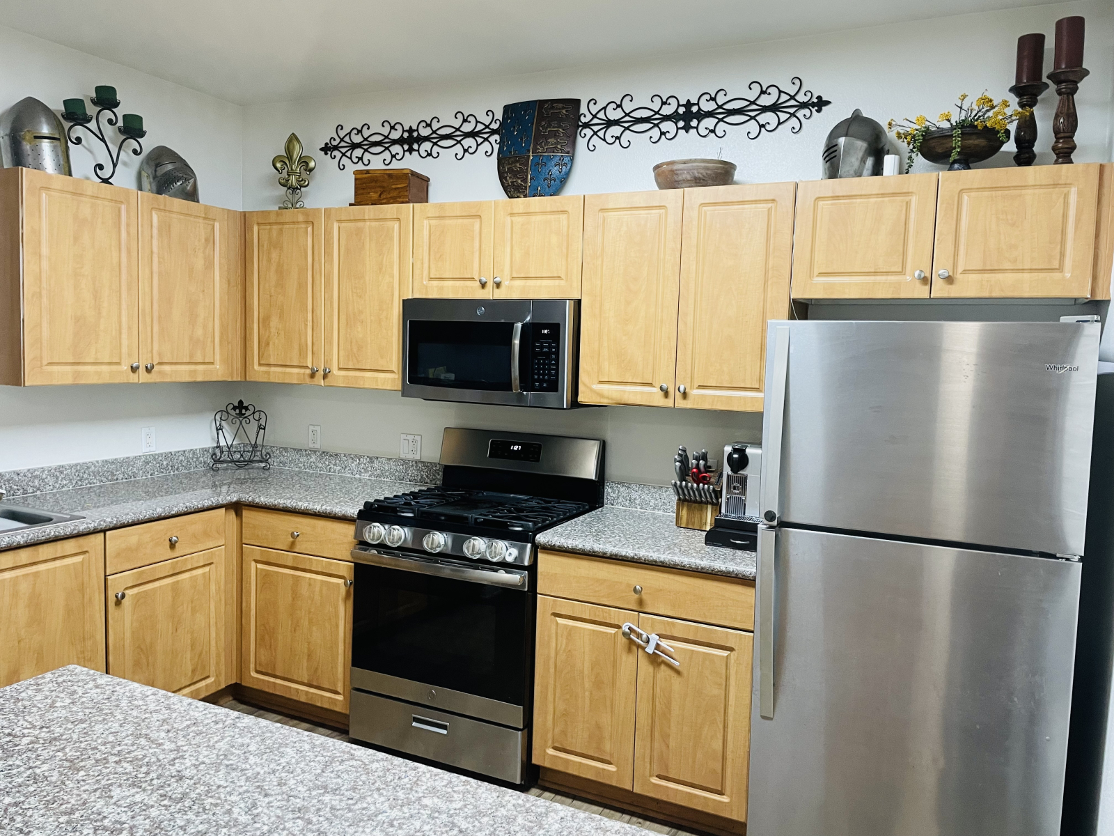 Küche mit Edelstahlgeräten. Babyproofing an einigen Schränken. Auf der Theke steht gerade eine Heißl ...