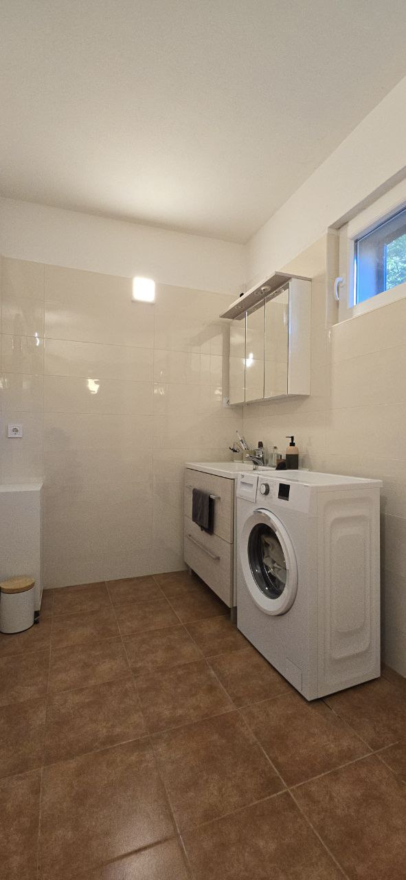 Left side of the bathroom with washing machine.