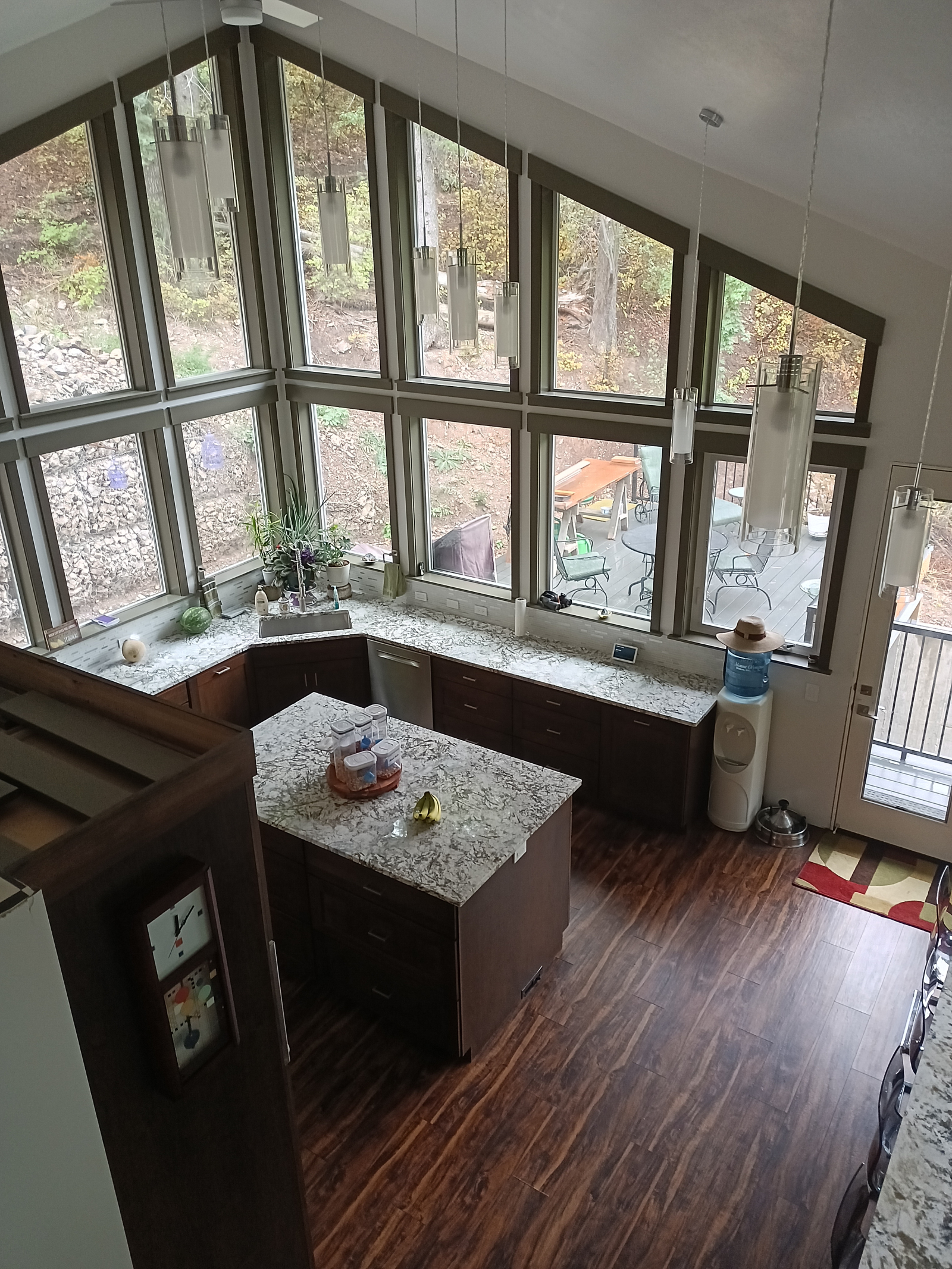 View from the mezzanine of the kitchen, rear door, rear deck and edge of dining table.
