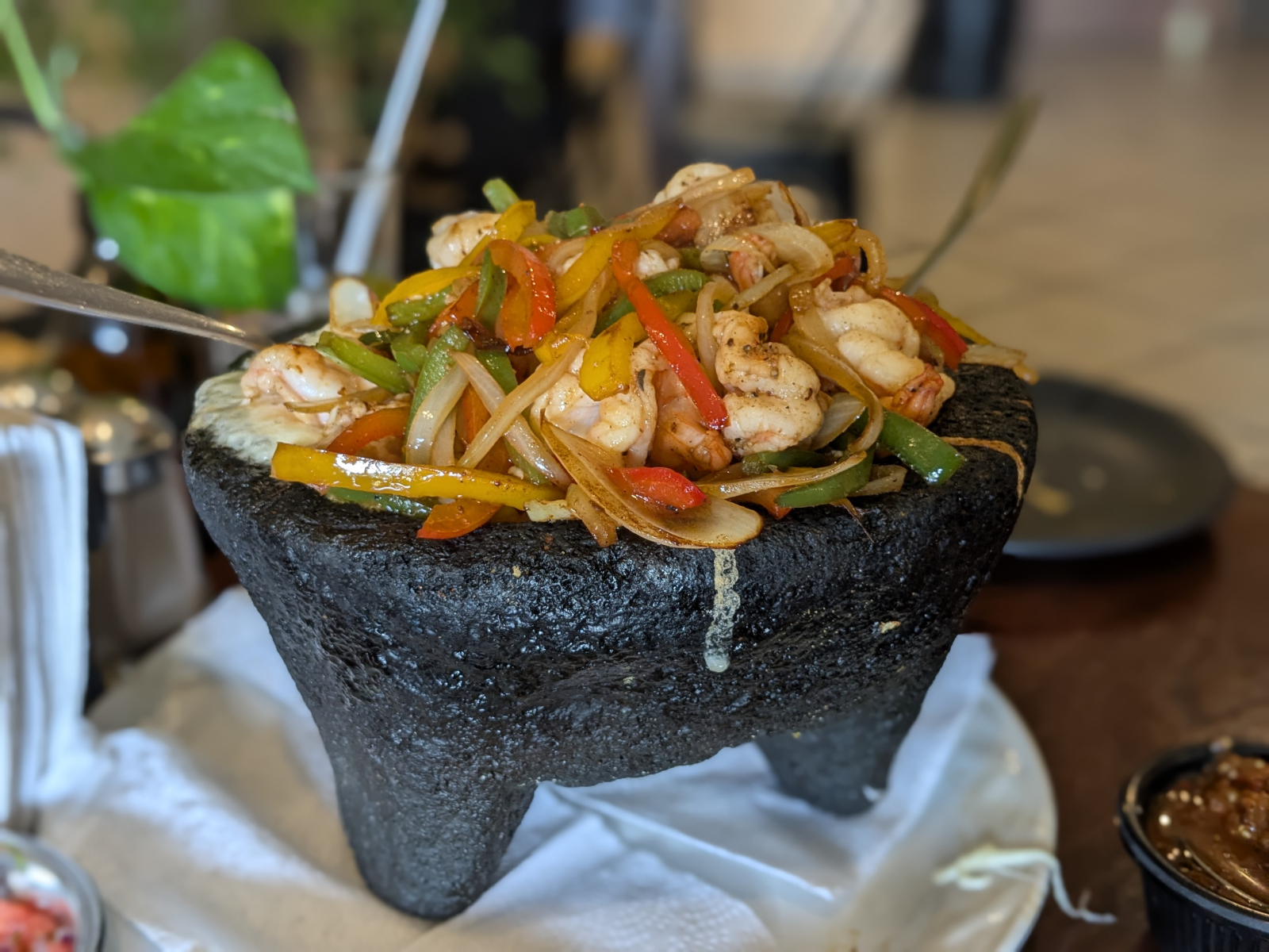 Um prato local - frutos do mar ou carne assada com legumes e queijo em um recipiente vulcânico