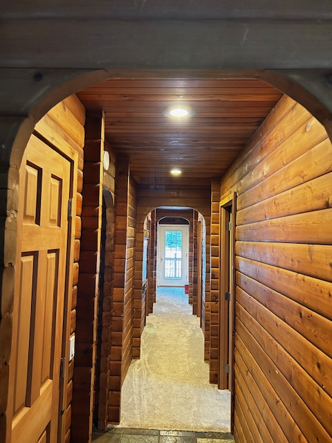 Couloir vers les chambres et la salle de bain. À droite se trouve une chambre avec un lit queen, à c ...