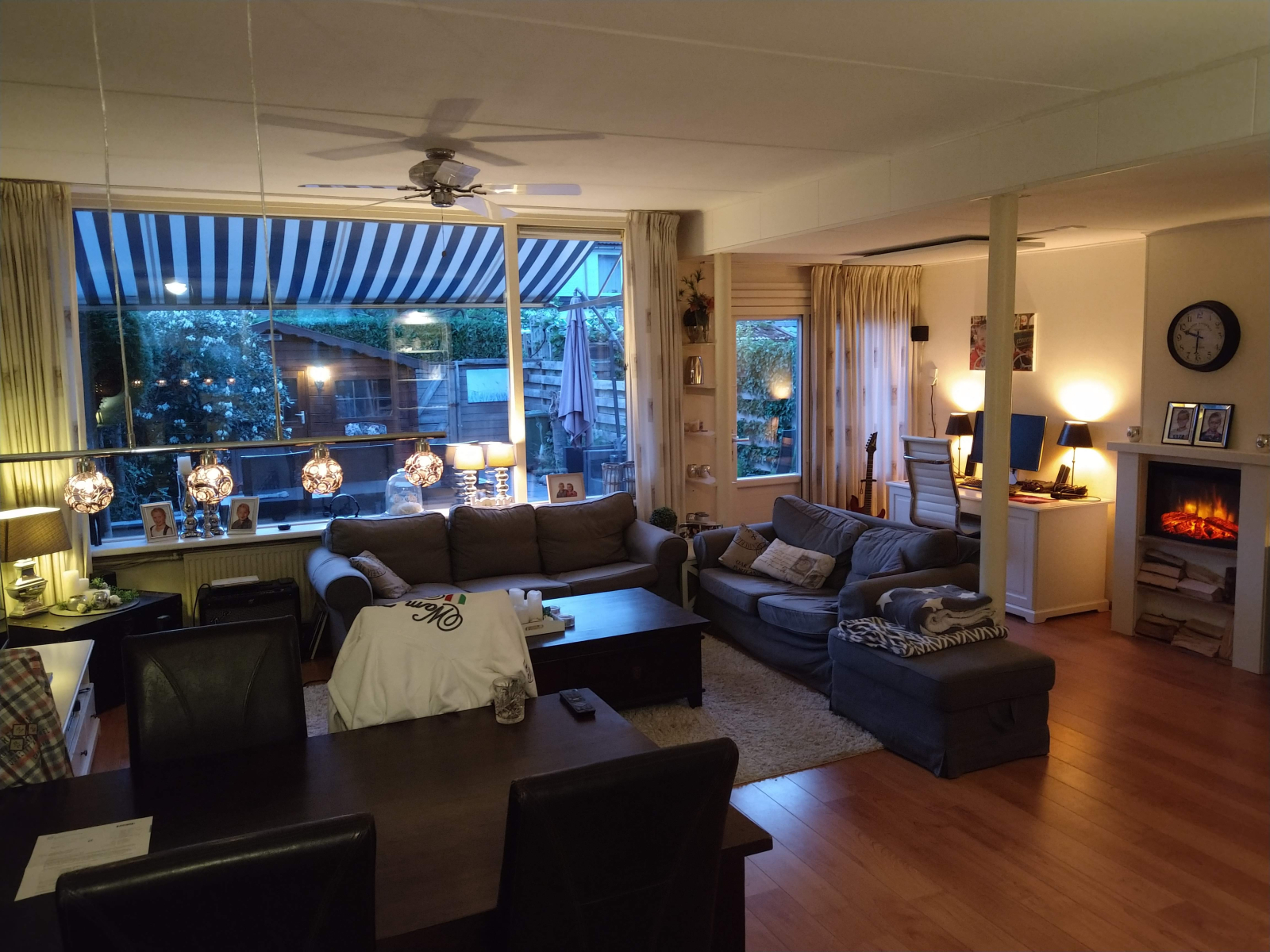 Bellissimo soggiorno spazioso con smart TV da 65 pollici, ventilatori e camino e PC.