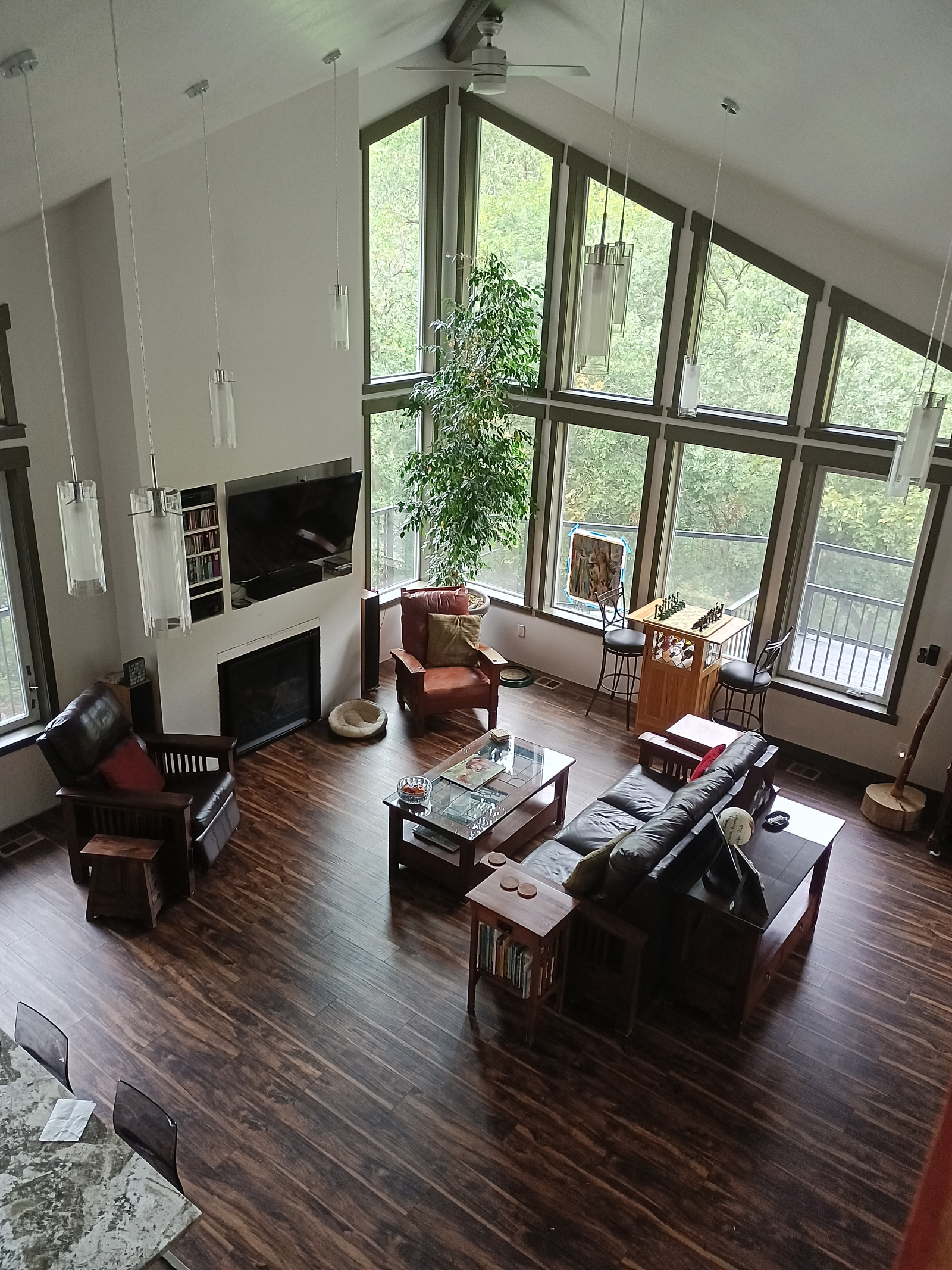 View from the mezzanine showing the family room, fireplace, TV and part of dining table.