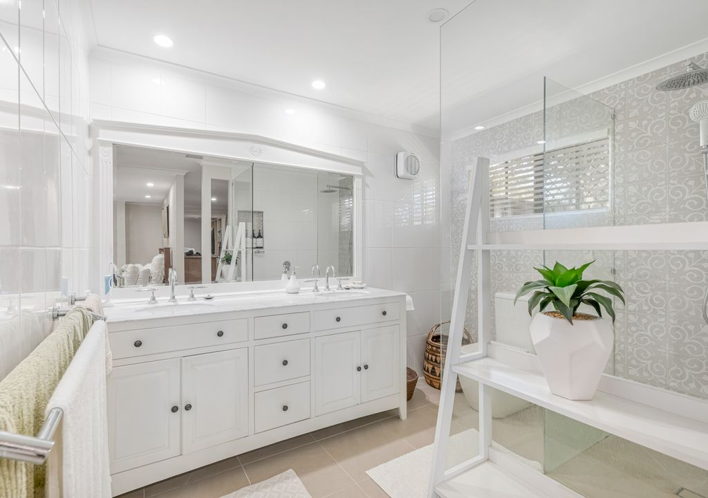 Salle de bain principale avec douche à l’italienne, meuble-lavabo et toilettes.