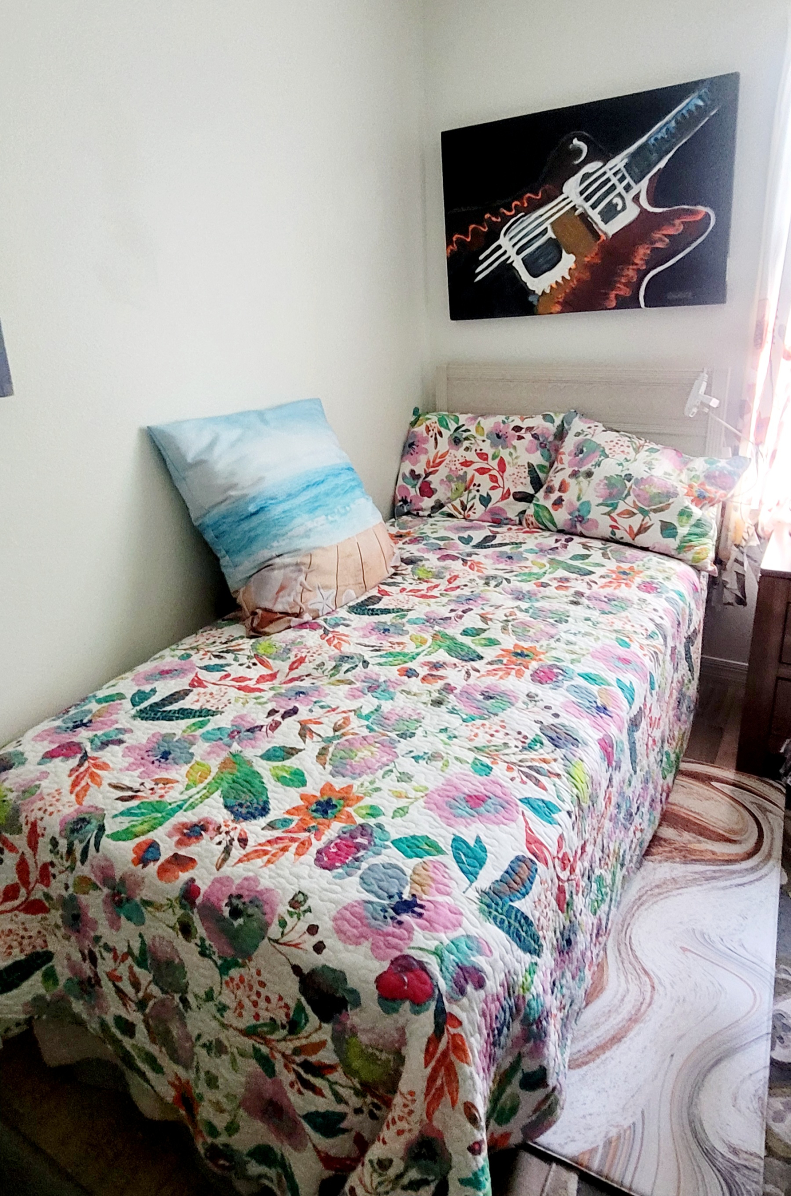 Quarto com cama de solteiro com geladeira, micro, cafeteira, escrivaninha.