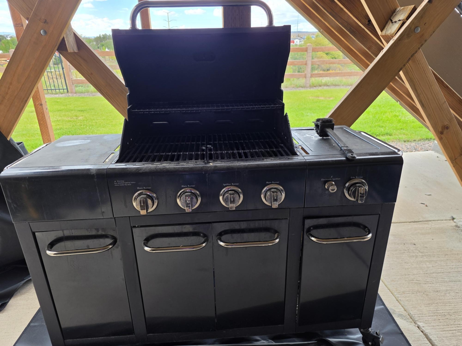 Grand barbecue sur la terrasse avec un seul brûleur latéral.
