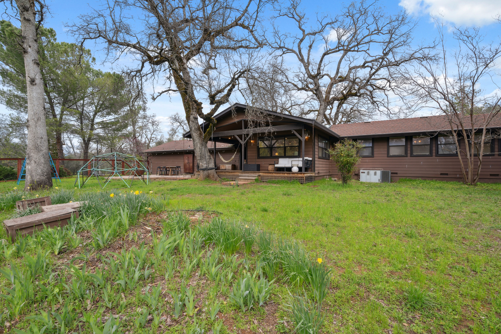 Ampio cortile recintato con ponte, patio, amaca, altalena e cupola per arrampicarsi.