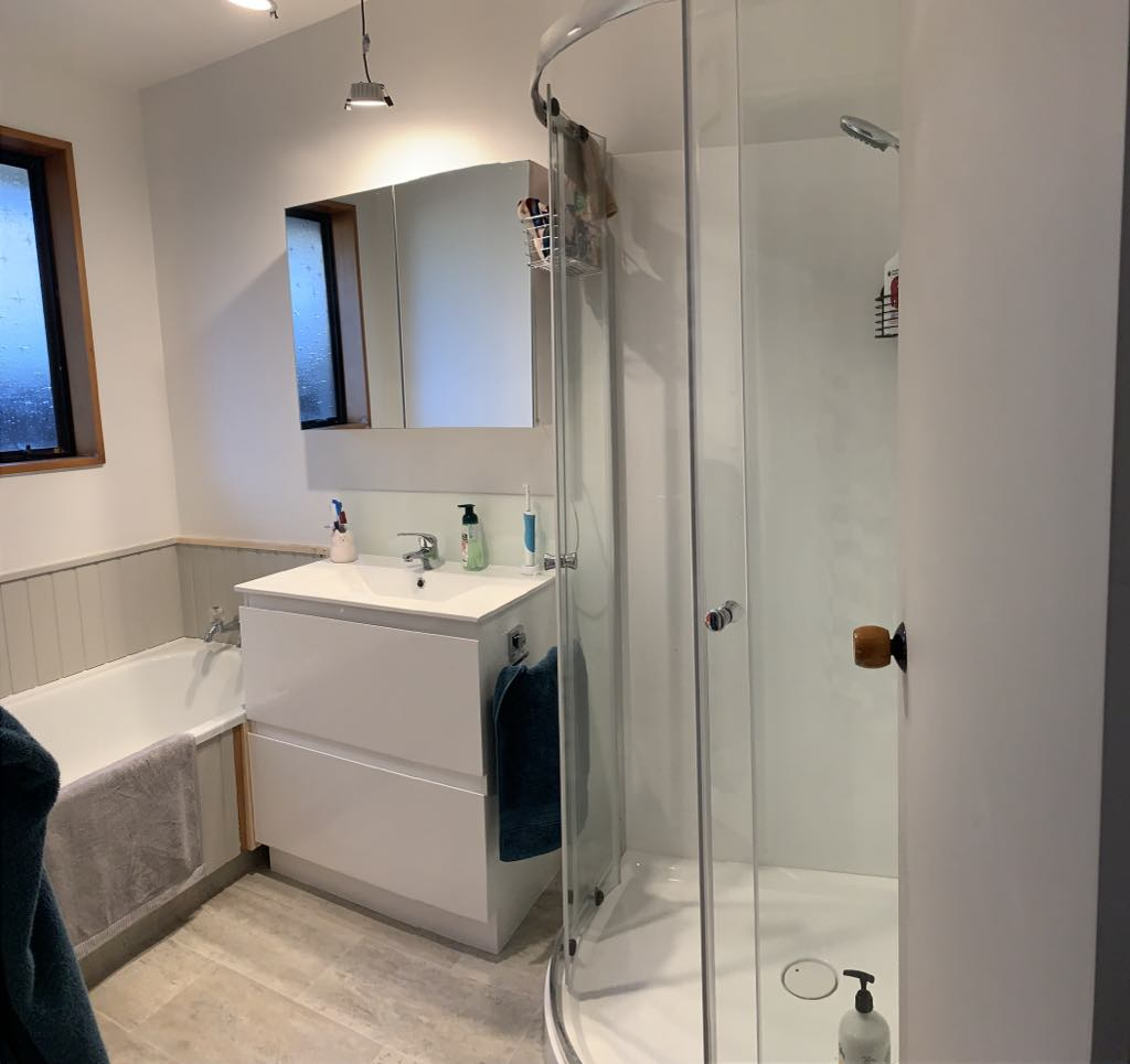 Modern bathroom with separate shower and bathtub, storage under vanity basin plus mirror, heated tow ...