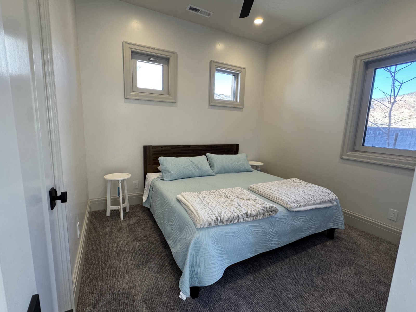 Chambre de gauche avec lit king size, porte de salle de bain attenante à gauche, ventilateur de plaf ...