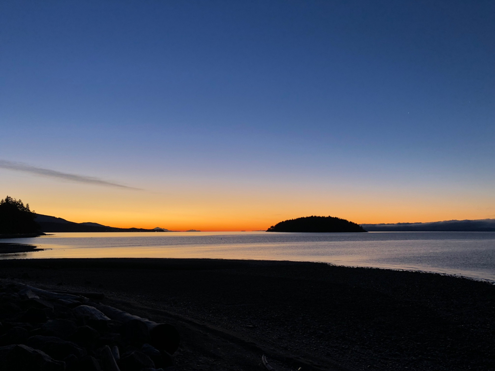 Sunrise with views of nearby Davis Bay and distant views on the horizon of the Olympic Mountains and ...