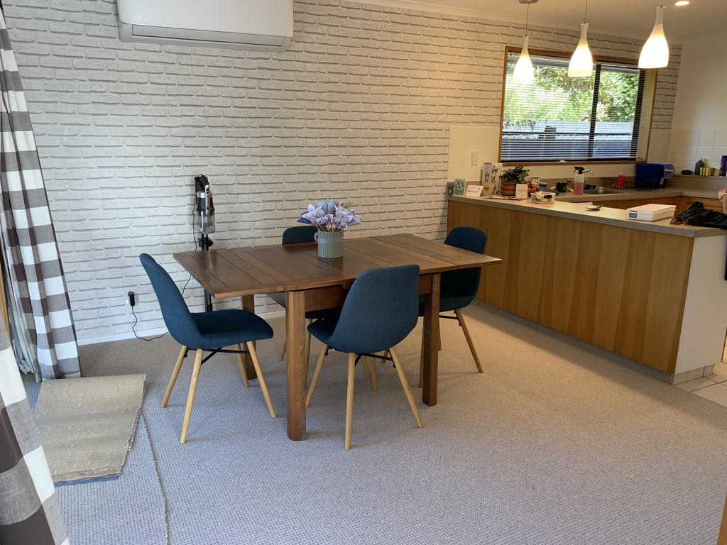 Dining room with dining table and heat pump/air con open into Kitchen and sliding doors out to side ...