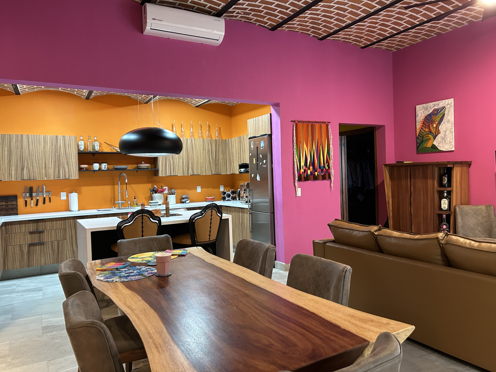 La cocina principal, el comedor y la sala de estar de concepto abierto están pintadas con colores in ...