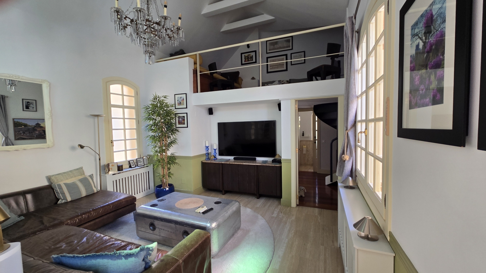 The sitting room with sectional leather sofa and TV