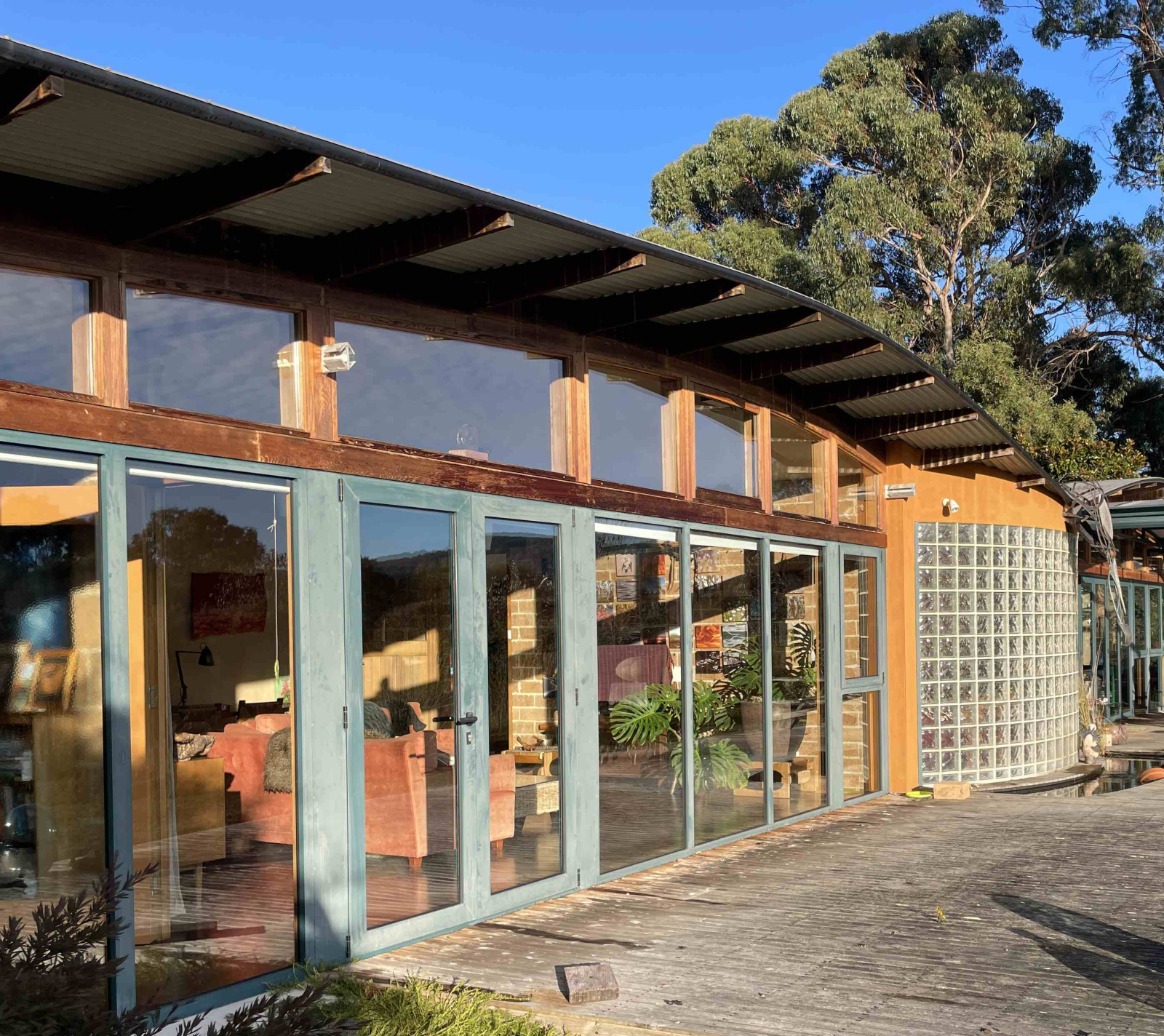 Les grandes fenêtres du côté ensoleillé de la maison descendent dans le sol et fournissent la grande ...