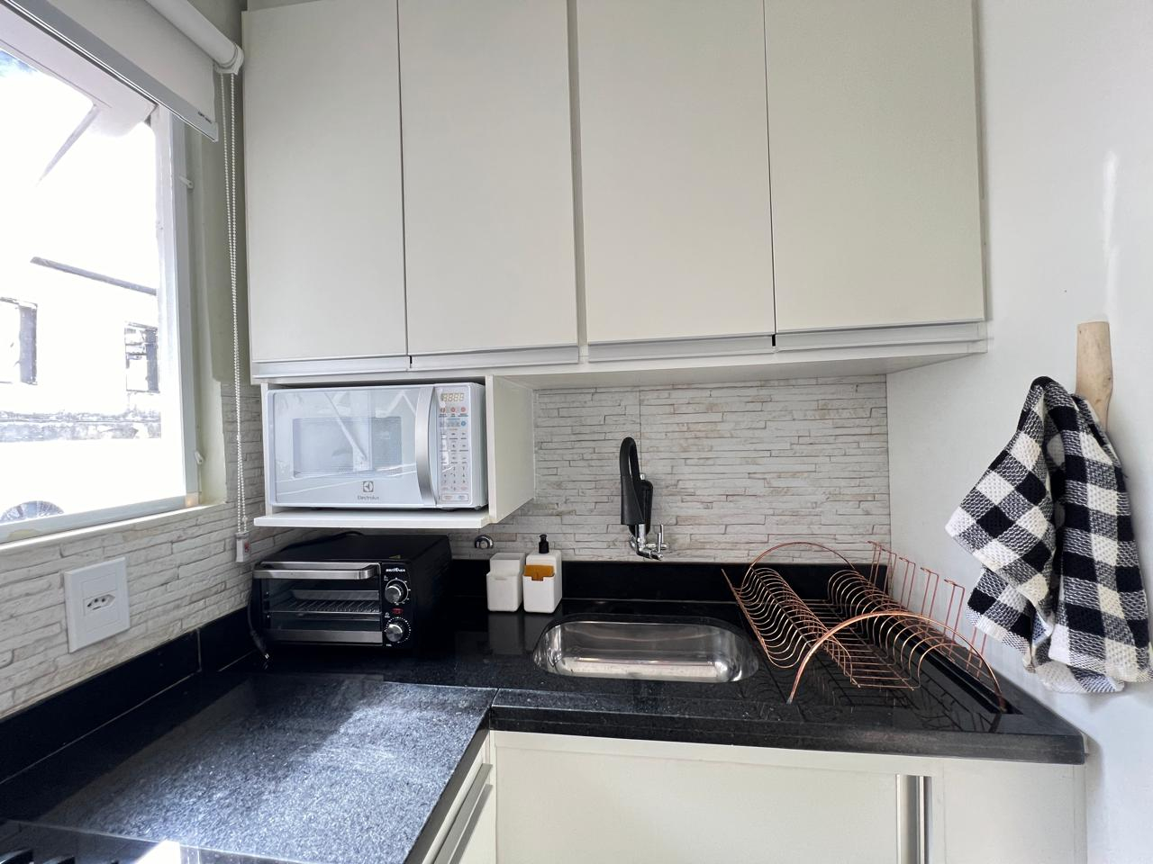 Cozinha - micro-ondas, mini-forno, geladeira, pia e cafeteira dentro dos armários