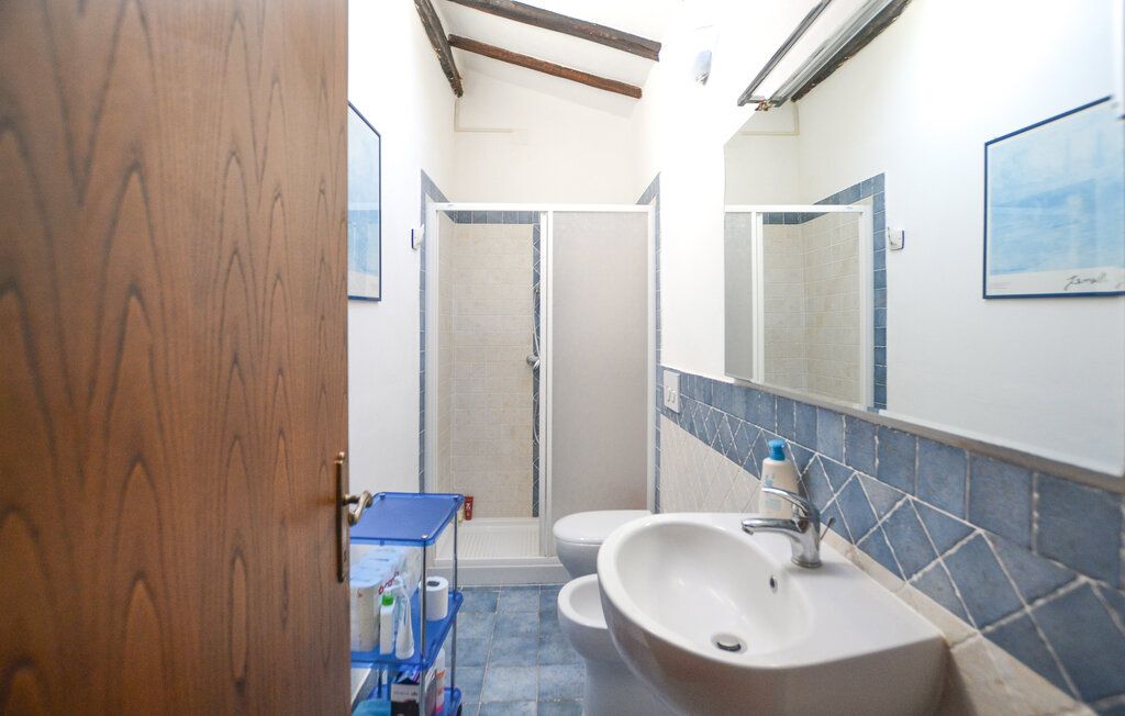La salle de bain au deuxième étage avec une grande douche et un hublot donnant sur le ciel.