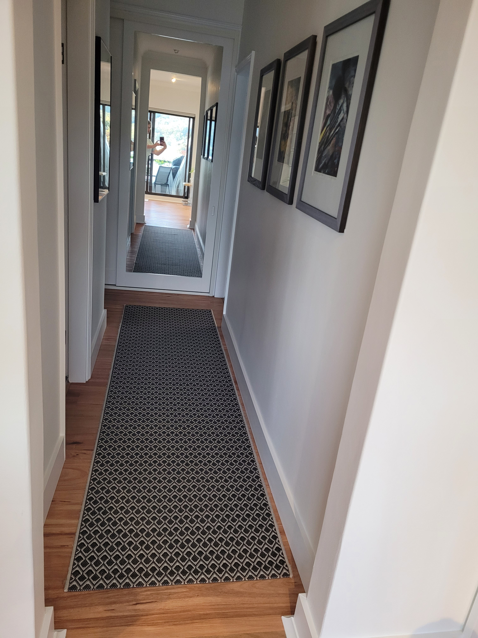 El pasillo conduce al baño principal a la izquierda y dos dormitorios a la izquierda y a la derecha ...