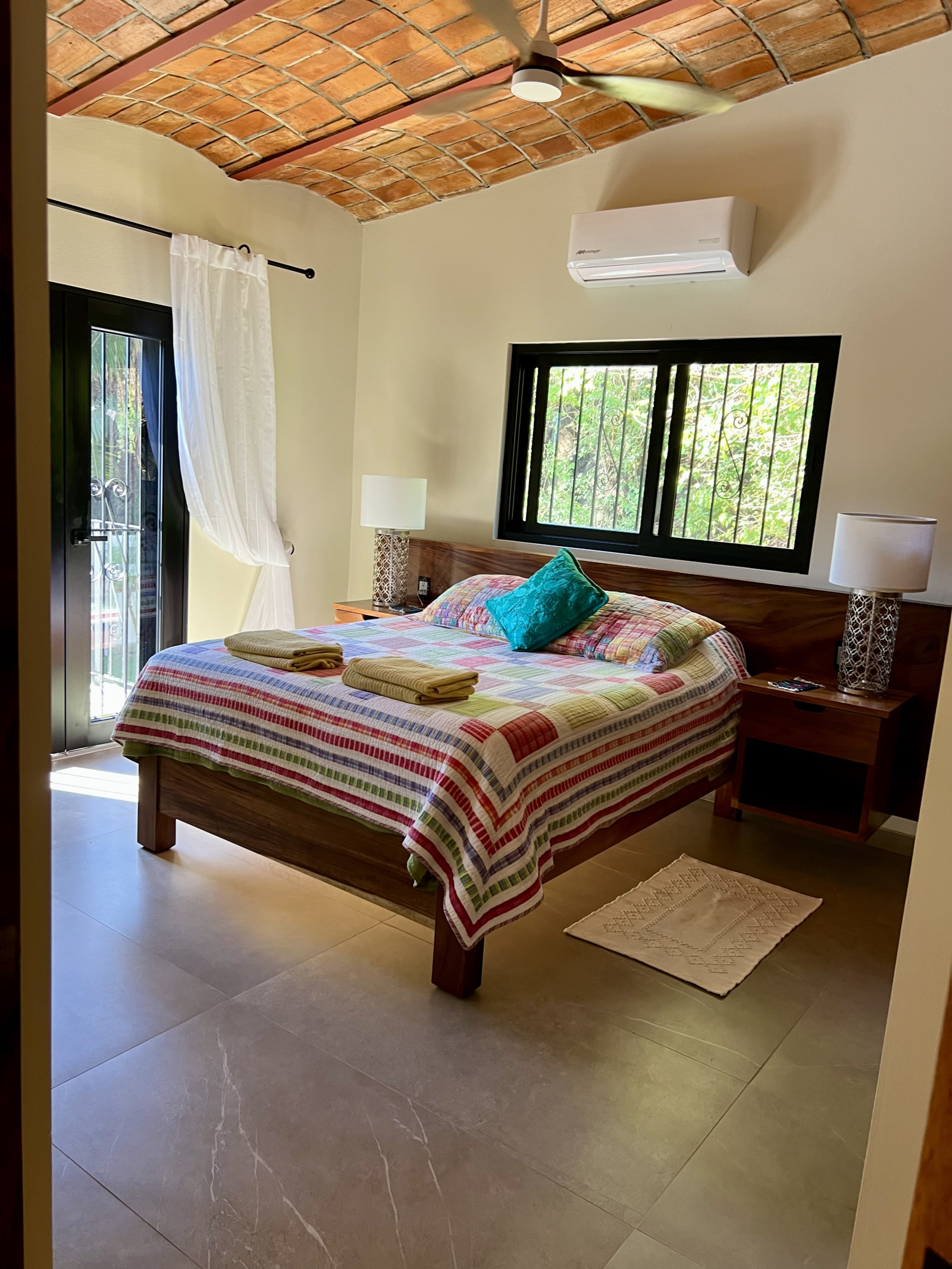 Dormitorio de invitados en la planta superior, cama Queen, con vista al área de la piscina