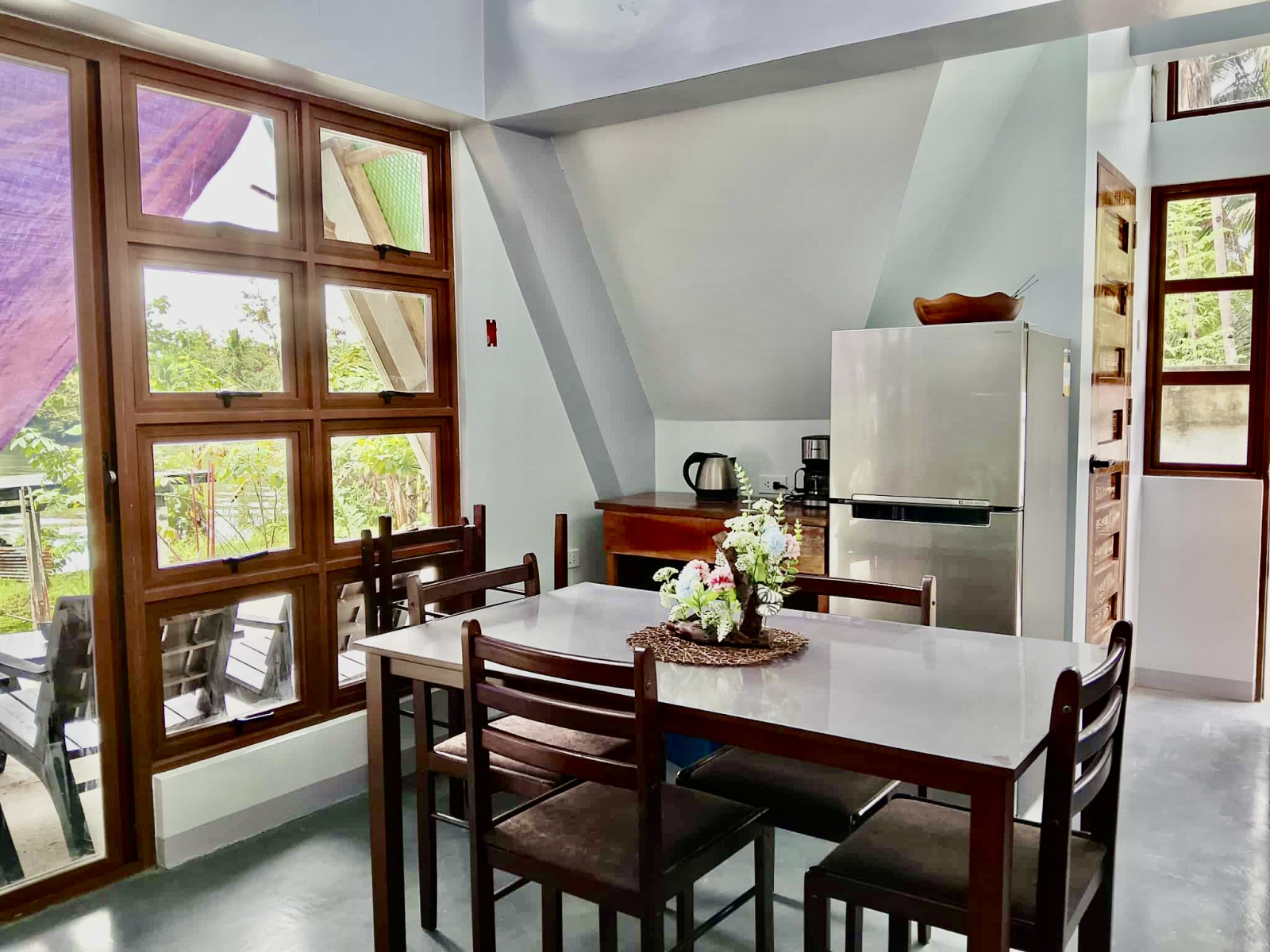 Eetkamer - eettafel met vier stoelen (twee extra stoelen bij het raam, koelkast, koffiezetapparaat, ...