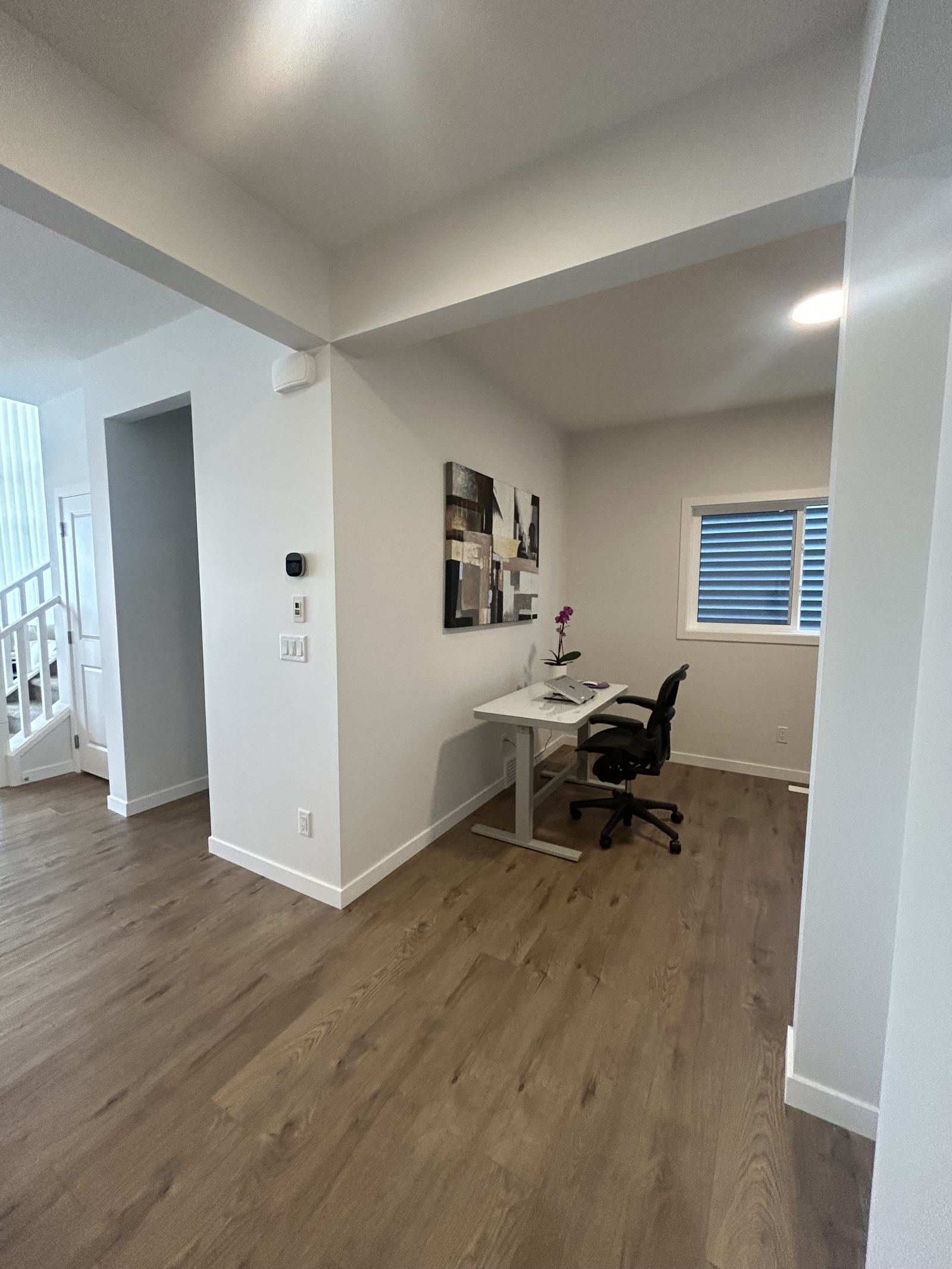 Open-concept work area with electric standing desk and ergonomic Herman Miller chair